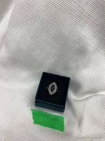 Ring in presentation box showing top view of filigree setting and black stone