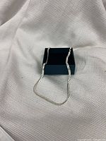 Full view of sterling silver necklace draped over box