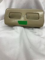 Top view of tan steel two-hole punch showing rectangular punch openings