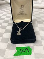 Pendant with chain in open velvet box, green sticker 109 visible
