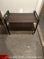 Full view of TV stand showing both shelves and wheels