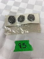 Front view of three miniature Special Police badges on backing card