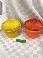 Yellow and rust orange Tupperware bowls with lids