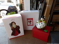 Packaging boxes with Hallmark Santa box, plain box, snowman displayed on red storage box