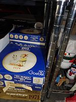 Stacked blue Goebel Hummel plate boxes showing 1974 and other years