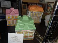 Three ceramic townhouse canisters grouped together
