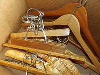 Box containing wood suit hangers, clamp pant hangers, padded cloth hangers