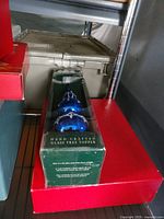 Boxed cobalt blue glass tree topper on shelf