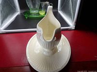 Gravy boat on attached stand showing pattern detail