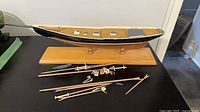 Overall view of wooden Bluenose model on stand with loose unattached parts laid out