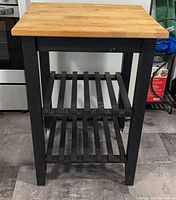 Front view showing butcher-block top, frame and shelves