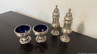 Group view of two sugar casters and two salt cellars