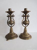 Full view of both bronze candle holders, showing size, design, base and side mounts
