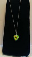 Full view of necklace on display showing heart crystal pendant and chain