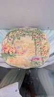 Front of octagonal dish showing hand-painted raised floral garden scene