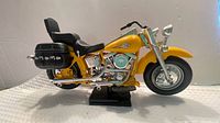 Right side view of yellow motorcycle model with stand