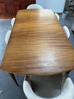 Top view of wooden dining table with four beige chairs around it