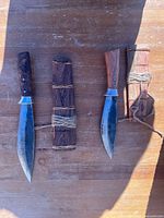 Overall view of both knives and sheaths on wood surface