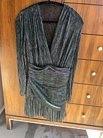 Full view of metallic teal/green lurex long-sleeve cocktail dress on hanger showing style and condition