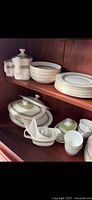 Overall view of china set on shelves showing plates, bowls, covered dishes, sugar, creamer