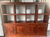 Front view showing eight open shelves and four lower cabinet doors