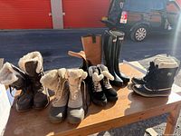 Group shot of all five pairs of boots on table outdoors
