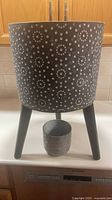 Large dotted planter on stand with small pot placed beneath