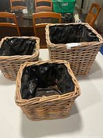 Three square wicker planters with liners on table