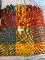 Folded throw showing plaid pattern and fringe