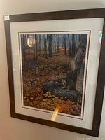Full view of framed print on wall showing raccoons scene and frame
