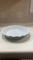 White scalloped-edge ceramic pie plate on countertop