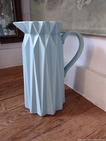 Full view of aqua faceted ceramic pitcher with handle