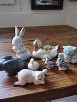 Group of eight assorted animal figurines displayed on wood surface