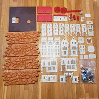 all castle parts laid out including bases, wall panels, roofs, accessories and bag of figures