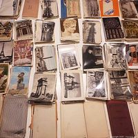 Stacks of vintage postcards spread across table