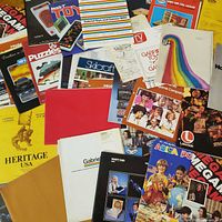 Pile of various vintage toy and game catalogs from multiple brands
