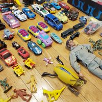 overall shot of assorted cars, figures, train parts and action figure