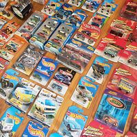 Wide view of numerous blister-carded Hot Wheels, Johnny Lightning and Matchbox cars spread on floor