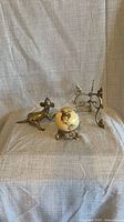 Group shot of globe, brass figurine and brass easel