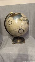 Full view of globe showing Americas and ornate bronze-tone base
