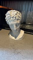 Front view of large white classical male bust figurine