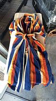 Top view of striped Christian Dior bath robe showing colors and belt