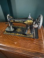 Close view of machine head showing Singer logo, decals, needle area and mounting in cabinet