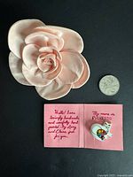 Fabric rose pin beside coin and Picatsso cat pin on card