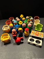 Group shot of figures, chairs, picnic table, bench and rooster