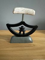 Complete assembled ulu sculpture showing bone handle, black stone blade section, grey base