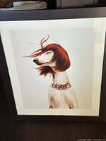 Full view of framed photo showing dog with red wig, frame and mat