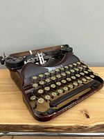 Front angled view of maroon Corona 4 typewriter showing keys and body
