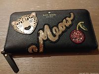 Front view showing leopard, "meow" sequin script and cherry patches, brand logo, zipper pull