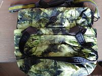 Front view of green camouflage Lululemon daypack with handles and logo visible